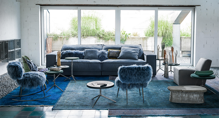 Stylish living room with a Suede sofa in blue, paired with serveral fashion chairs and side tables